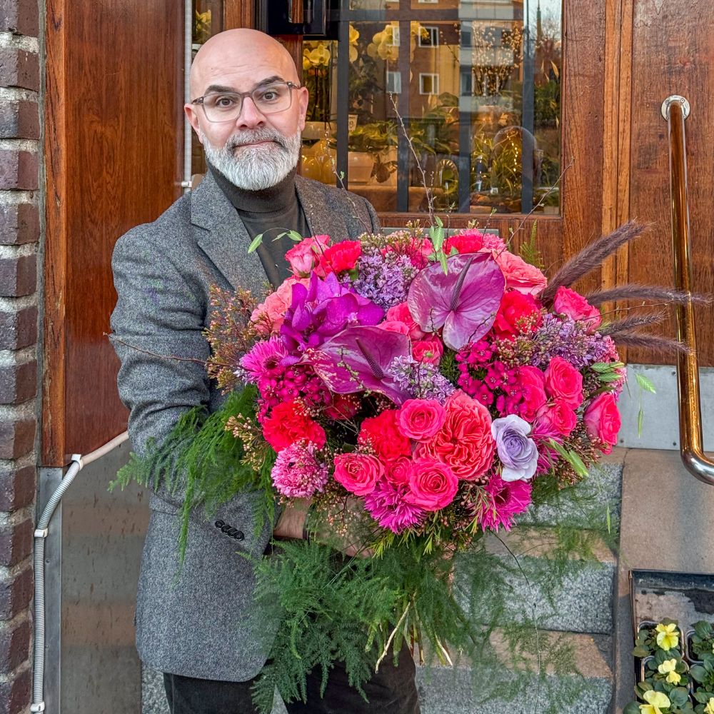 Finalist från Interflora Sundbybergs Blomsterhandel håller den magnifika vinnarbuketten för Finalen