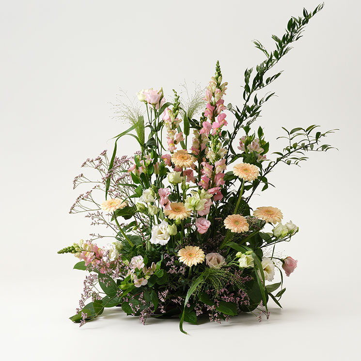 Hög begravningsdekoration - beställ hos Interflora! Hög begravningsdekoration, med germini, prärieklocka, alstroemeria och lejongap. Ljusa rosa och aprikosa färgtoner. Skicka med ett blommogram från Interflora direkt till begravningen!