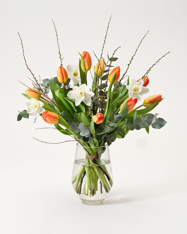 Interfloras februaribukett med orange tulpaner, vita narcisser, spireakvistar och eucalyptusblad.
