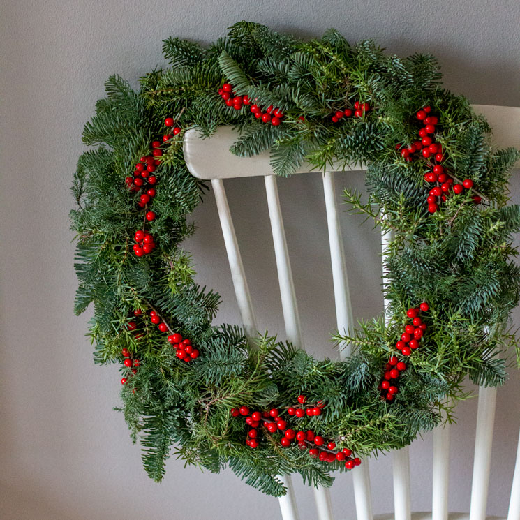 Julkrans med gröna barrkvistar och röda bär. Diameter 30 cm. Julkransen finns att beställa hos Interflora.